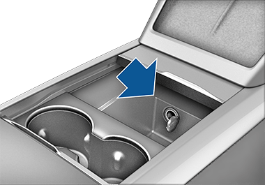 Центральная консоль с поднятым подлокотником, в отсеке видна розетка